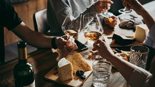 Freunde genießen italienische Kulinarik mit ausreichend Wein und Käse