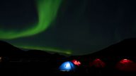 Zelten auf Island in der freien Natur mit Nordlichtern im Himmel