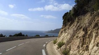 Aphaltierte Straße entlang der Küste auf Korsika