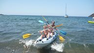 Ein Vater paddelt auf dem Meer in Korsika