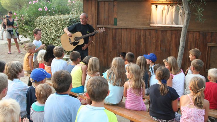 Ein Animateur im Feriendorf unterhält eine Gruppe Kinder