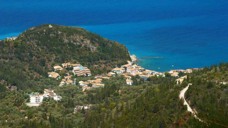 Blick von der natürlichen Bergwelt auf griechisches Dorf mit Strand und Meer