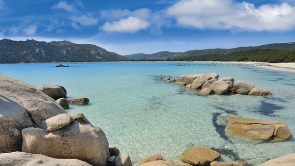 Glasklares Wasser und glatte Felsen schmücken die Bucht von Castell Verde